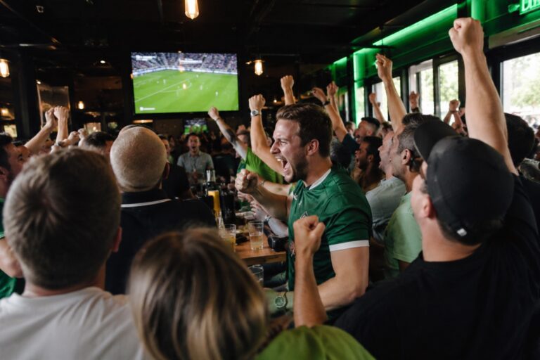 Football fans cheering together in a sports bar during a live match